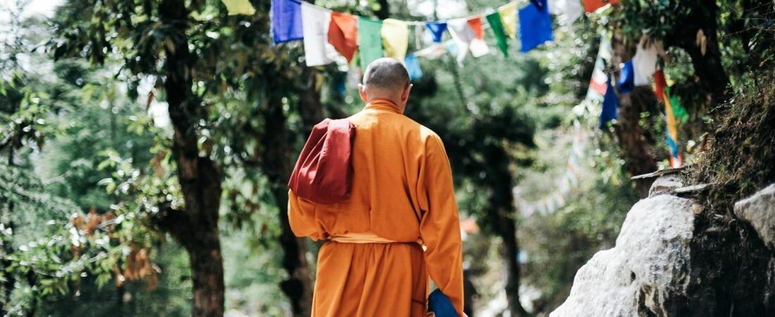 monk walking near buntings during day